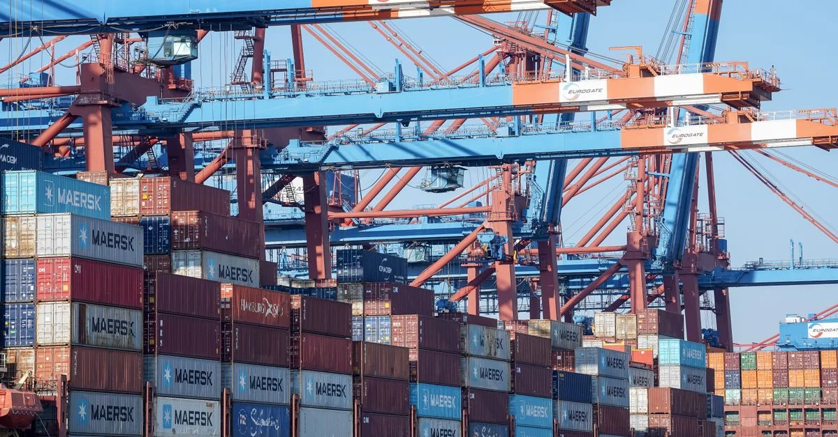 Une vue animée du port de Hambourg montrant des grues et des conteneurs empilés.