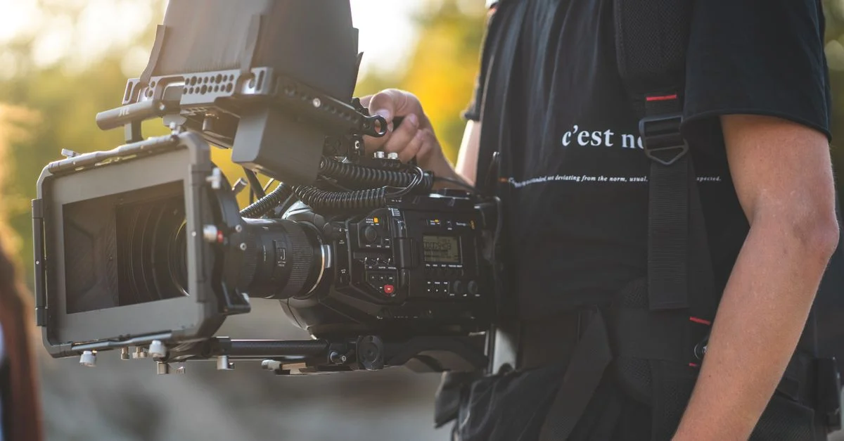 Gros plan d'un opérateur de caméra professionnel utilisant un grand rig de caméra en extérieur.