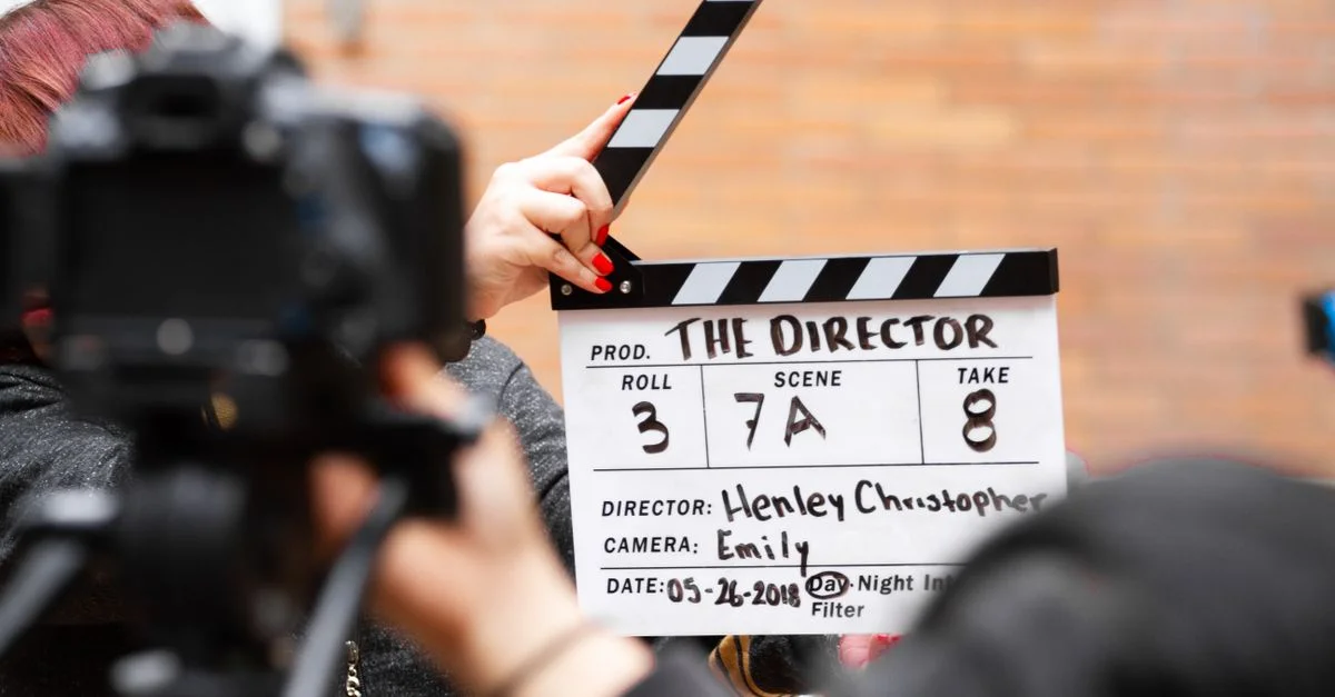Gros plan sur un clap de film en action avec la caméra filmant une prise sur le plateau.